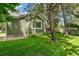 Well-maintained home exterior with green siding, a lush lawn, and mature trees at 7400 W Grant Ranch Blvd # 52, Littleton, CO 80123