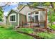 Home with green siding with backyard wooden deck with mature landscaping and small garden at 7400 W Grant Ranch Blvd # 52, Littleton, CO 80123