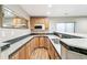 Modern kitchenette with wooden cabinets, tiled backsplash, stainless steel sink, and wood-look flooring at 7400 W Grant Ranch Blvd # 52, Littleton, CO 80123