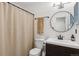 Classic bathroom showcasing a round mirror, updated vanity, and a shower with modern black accents at 8555 Fairmount Dr # B202, Denver, CO 80247