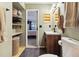Modern bathroom offering open shelving, a stylish vanity, and a view into the Primary bedroom at 8555 Fairmount Dr # B202, Denver, CO 80247