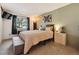 Cozy bedroom with an upholstered bench, a wooden headboard and natural light from the window at 8555 Fairmount Dr # B202, Denver, CO 80247