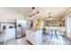 An open concept kitchen with stainless steel appliances, modern lighting, and seamless flow into adjacent dining and living areas at 11301 Vernon Way, Parker, CO 80134