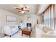 Bright living room with a fireplace, ceiling fan, wood blinds, and comfortable seating at 11301 Vernon Way, Parker, CO 80134