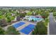 Aerial view of a community pool area with tennis courts, surrounded by green trees and manicured lawns at 11301 Vernon Way, Parker, CO 80134