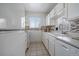 Clean kitchen featuring white cabinets, tiled backsplash, and modern appliances at 8798 Chase Dr # 4, Arvada, CO 80003