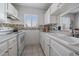 Galley kitchen with updated appliances, white cabinetry and tiled backsplash at 8798 Chase Dr # 4, Arvada, CO 80003