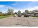 Cars parked in a community parking lot next to townhouses with green space at 8798 Chase Dr # 4, Arvada, CO 80003
