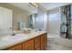 Bathroom with double sinks, shower/tub combo, and wood cabinets at 3925 Broadview Pl, Castle Rock, CO 80109