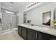 Modern bathroom featuring double sinks, a granite countertop, and a glass enclosed shower stall at 5278 Warrior St, Frederick, CO 80504