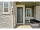 Cozy front porch with stone accents, comfortable seating, and a modern door with glass insert, perfect to relax at 5278 Warrior St, Frederick, CO 80504