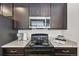 Close-up of modern black appliances, dark cabinetry, and granite countertop at 5278 Warrior St, Frederick, CO 80504