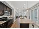 Open-concept kitchen featuring stainless appliances, dark cabinetry, an island with a granite countertop, and an eat-in bar area at 5278 Warrior St, Frederick, CO 80504