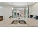 Kitchen island close-up showcasing a stainless sink, faucet, stylish pendant lights, and sliding glass doors to the outside at 5278 Warrior St, Frederick, CO 80504