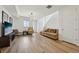 Open-concept living room with hardwood floors, a large window, and modern decor, perfect for entertaining guests at 5278 Warrior St, Frederick, CO 80504