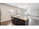 Modern kitchen island with sink, dark cabinets, and hardwood floors at 6104 Black Mesa Rd, Frederick, CO 80516