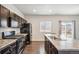 Modern kitchen with stainless steel appliances and dark cabinets at 6104 Black Mesa Rd, Frederick, CO 80516