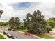 A street view framed by mature trees with well-maintained sidewalks and colorful landscaping at 2280 S Oswego Way # 303, Aurora, CO 80014