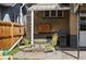 Cozy backyard patio with green chairs, table, and grill, perfect for outdoor dining and relaxation at 3415 N Vine St, Denver, CO 80205
