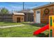 Spacious backyard featuring a wooden playhouse, storage shed, slide and a lush green lawn at 3415 N Vine St, Denver, CO 80205