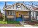 Charming home exterior with a front porch, bright yellow door, and well-manicured landscaping at 3415 N Vine St, Denver, CO 80205