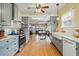 Open-concept kitchen featuring stainless appliances, marble counters, gray cabinets, and hardwood floors at 3415 N Vine St, Denver, CO 80205