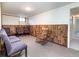 Finished basement with wood-paneled accent wall featuring multiple seating options for various activities at 6847 S Hill St, Littleton, CO 80120