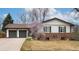 Charming home featuring a two-car garage, brick accents, and blossoming tree in the front yard at 6847 S Hill St, Littleton, CO 80120