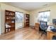Spacious home office with built-in bookshelves, hardwood floors, and natural light from two windows at 6847 S Hill St, Littleton, CO 80120