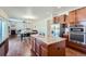 Kitchen island with granite countertops and hardwood floors leading to living and dining areas in an open floorplan at 42367 Glen Abbey Dr, Elizabeth, CO 80107