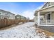 Spacious backyard with snow-covered grass, wooden fence, and covered patio area at 14119 Glencoe St, Thornton, CO 80602