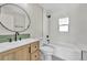 Modern bathroom with round mirror, updated vanity, and shower-tub combination at 6631 E 77Th Pl, Commerce City, CO 80022