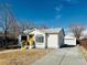 View of the house, freshly poured driveway and detached garage at 6631 E 77Th Pl, Commerce City, CO 80022