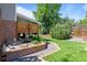Landscaped backyard with mature trees, a decorative fountain, and a serene outdoor setting at 2117 S Balsam Ct, Lakewood, CO 80227