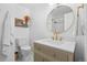 Bathroom featuring a toilet, sink, and round mirror at 2117 S Balsam Ct, Lakewood, CO 80227