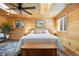 Bedroom featuring a ceiling fan, two windows, and natural wood plank walls and ceiling at 2117 S Balsam Ct, Lakewood, CO 80227