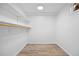 Walk-in closet with built-in shelving, wood-look flooring, and neutral-colored walls for ample storage at 2117 S Balsam Ct, Lakewood, CO 80227