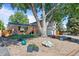 Charming front exterior of home featuring a brick facade, front yard landscaping, and a red door at 2117 S Balsam Ct, Lakewood, CO 80227