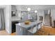 Stylish kitchen with gray cabinets, island seating, and a view towards the staircase and living area at 2117 S Balsam Ct, Lakewood, CO 80227