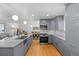 Bright kitchen with stainless steel appliances, gray cabinetry, and a view into adjacent living and dining areas at 2117 S Balsam Ct, Lakewood, CO 80227
