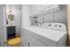 Efficient laundry room with modern appliances, overhead cabinets, and a utility sink at 2117 S Balsam Ct, Lakewood, CO 80227