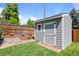 Backyard storage shed with a well-maintained exterior, surrounded by lush greenery, rocks, and mulch at 2117 S Balsam Ct, Lakewood, CO 80227