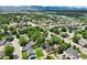 Neighborhood aerial view showcasing lush greenery, a lake, and mountain views at 3784 Swadley St, Wheat Ridge, CO 80033