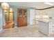 Open kitchen design with tiled floors, island, and a pantry, with a doorway to the entryway at 3784 Swadley St, Wheat Ridge, CO 80033