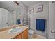 Well-lit bathroom with a toilet, sink, mirror, and some art pieces on the wall at 12711 Colorado Blvd # 914, Thornton, CO 80241
