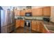 Well-lit kitchen with stainless steel appliances, wood cabinets and dark countertops at 12711 Colorado Blvd # 914, Thornton, CO 80241