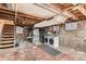 Unfinished basement with exposed brick, laundry area, and utility connections at 1612 N High St, Denver, CO 80218