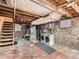 Unfinished basement with exposed brick, stairs, and laundry area with machines at 1612 N High St, Denver, CO 80218