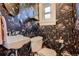Stylish powder room featuring unique wallpaper, a modern sink, and elegant fixtures at 1612 N High St, Denver, CO 80218
