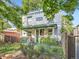 Charming two-story brick home with green accents, lush garden, and inviting front porch at 1612 N High St, Denver, CO 80218